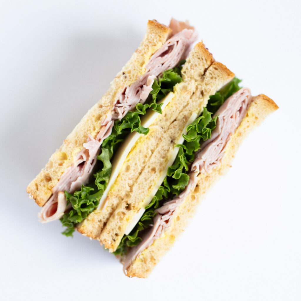 ham and swiss sandwich on a white background