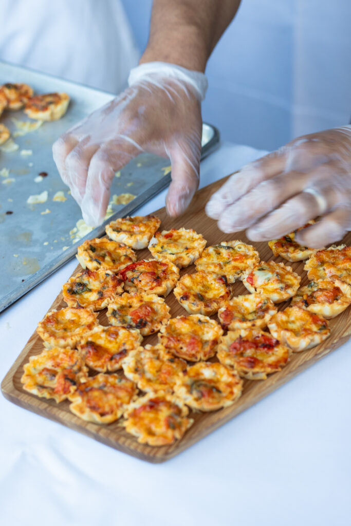 server preparing tomato basil tartlets