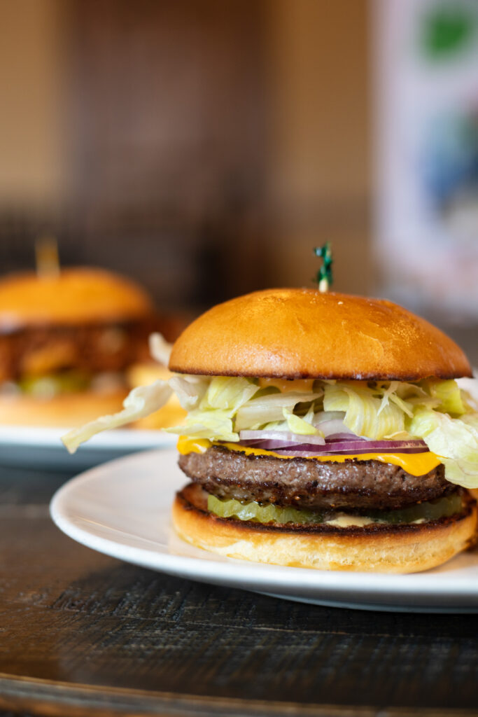 cheeseburger on a white plate in the the Corbett room at Elephants